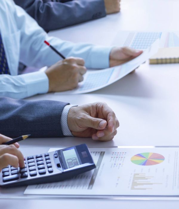 Businessmen in a meeting room are deeply reviewing financial statements and reports for a return on investment or investment risk analysis.